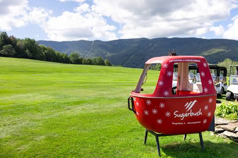 view of sugarbush gondola on golf course in summer