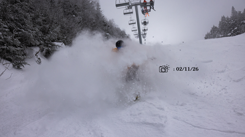 Skier in a yellow jacket in deep powder