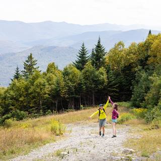 Two People high-fiving on a trailside at the resort 