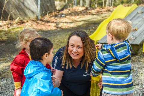 Adult engaging with young children during an outdoor playtime activity at Sugarbush Resort.