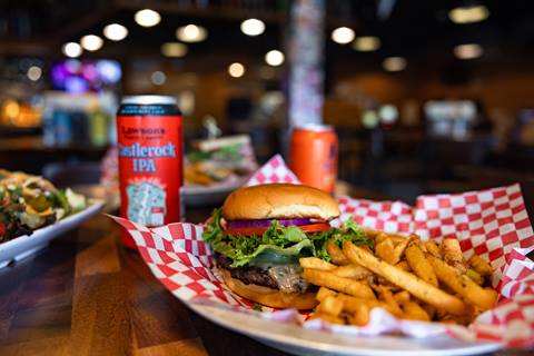 Castlerock IPA and a burger and french fries sitting on a table. 