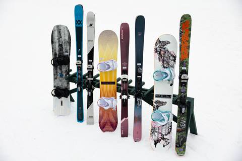 demo skis and snowboards on display in snow