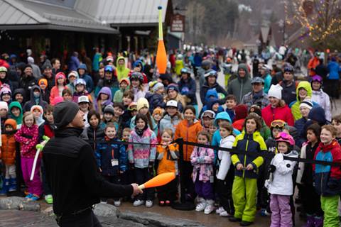 juggler performs in front of crowd of kids