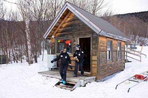 ski patrollers walking out of patrol shack