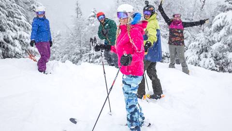 A group laughing and skiing