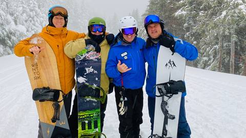 A group of snowboarders posing for the camera