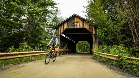 Gravel biker at a covered bridge