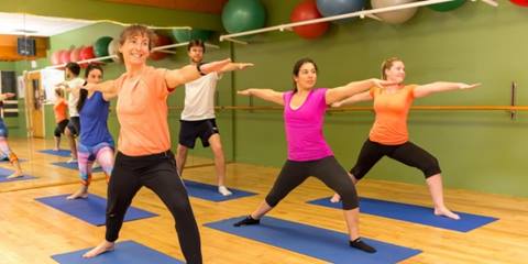 A group of people practicing yoga in a studio class at Sugarbush.