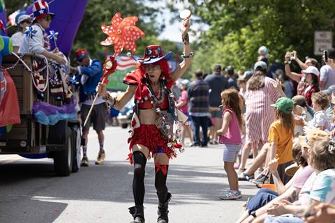 A women in red walking through the Warren 4th of July Parade