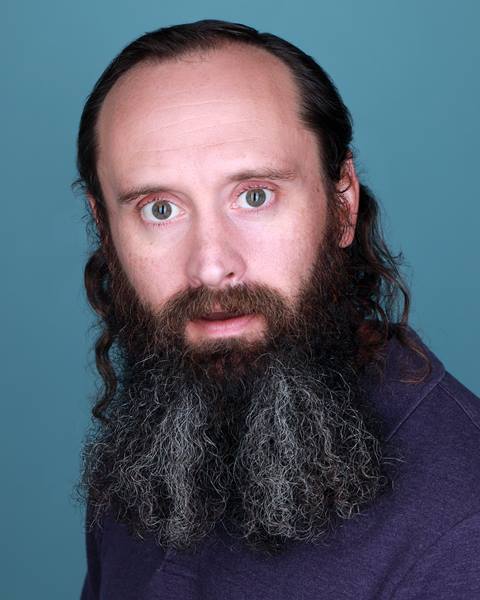Portrait of a bearded man against a studio background featured in content about Sugarbush Resort.