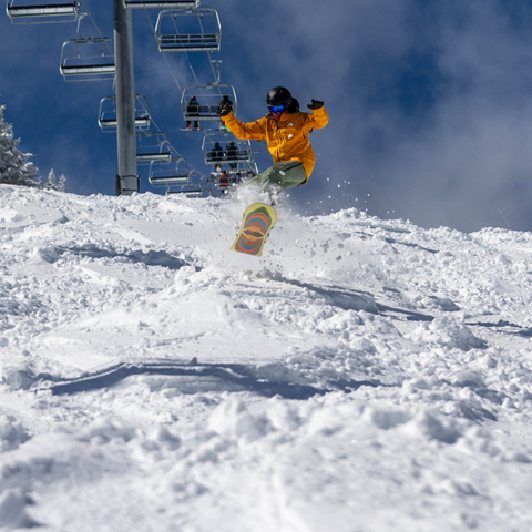 A man in a yellow jacket with blue sky in the background