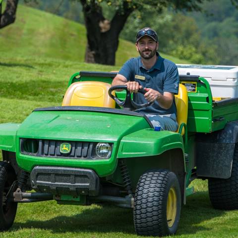 An employee riding a mower