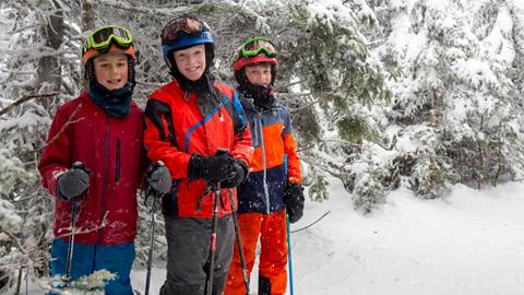 Kid skiing or snowboarding in a lesson