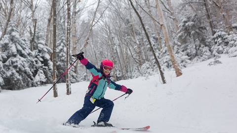 Kid skiing or snowboarding in a lesson
