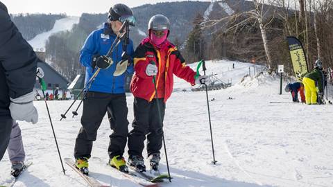 Instructor guiding a beginner skier on a learning slope at Sugarbush Resort