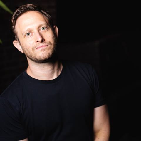 headshot of a comedian in the dark