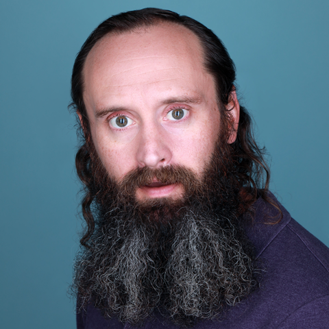 headshot of comedian on blue backdrop