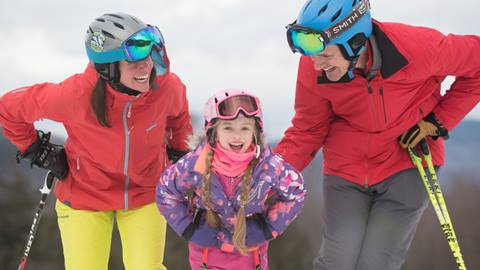 A family of five on hill smiling at the camera