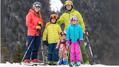 A family of five on hill smiling at the camera