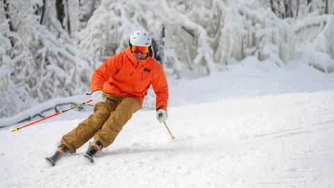 A guy skiing in a bight jacket