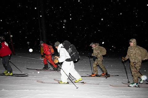 skiers touring at night with rucksacks