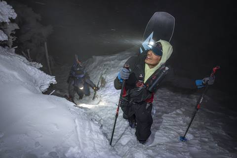 snowboarder hiking at night