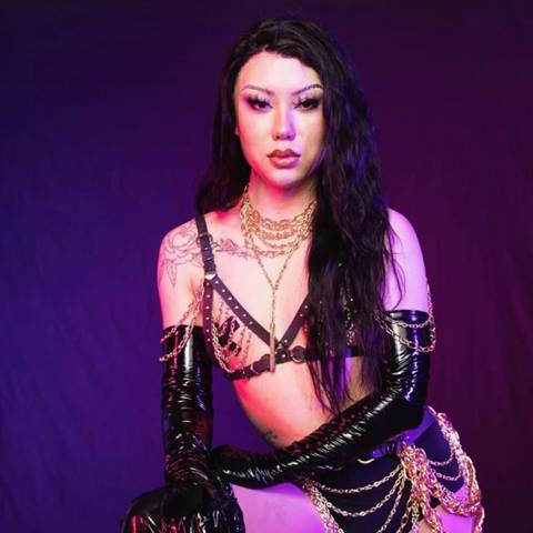 headshot of drag queen sasha sriracha in front of a purple backdrop