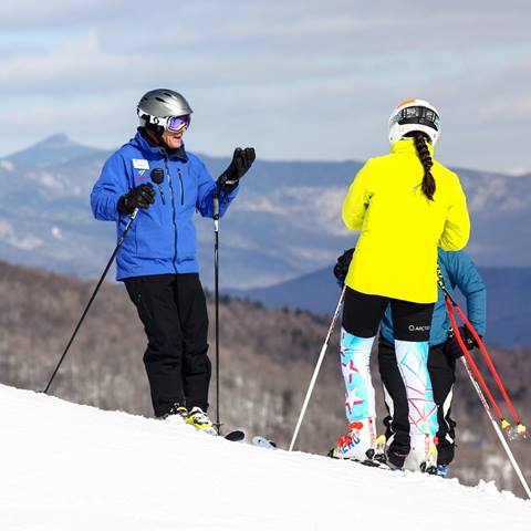 An instructor instructing an adult with Camels Hump in the background