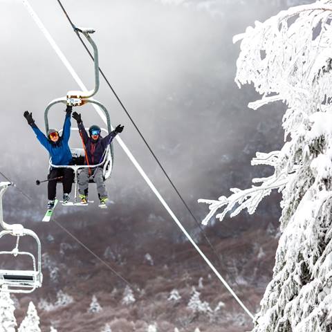 Friends waving on the Castlerock Lift at the camera