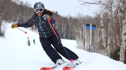 A women skiing and smiling at the camera