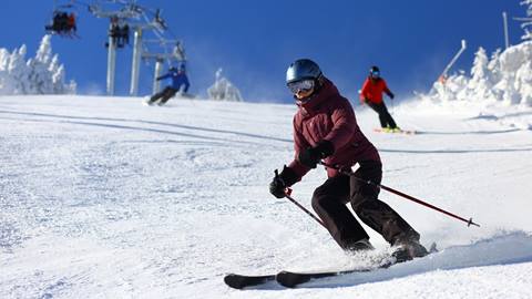 A women skiing down Ripcord