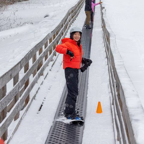 A women snowboarding on the Welcome Mat Lift