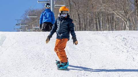 A little boy snowboarding