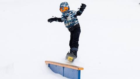 A little boy snowboarding