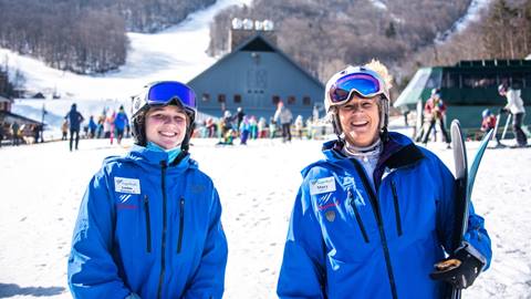 A young and older instructor smiling at camera