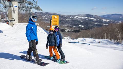 A group of kids snowboarding with an instructor