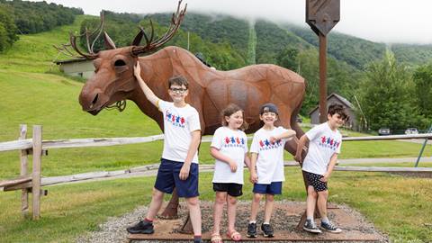 A group of kids smiling posing for a photo with 4th of july t-shirts on
