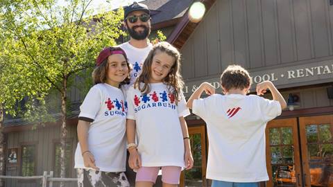 A group of kids smiling posing for a photo with 4th of july t-shirts on