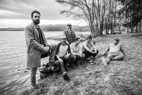 Members of the band Cabinet next to a lake