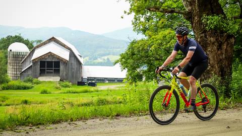 Gravel biker in front of an old barn