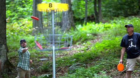 Folks playing disc golf