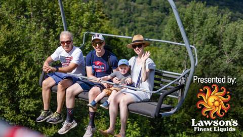 Family on a chairlift, waving, with a lawson's finest logo over the corner
