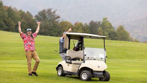 A guy cheering on the golf course 