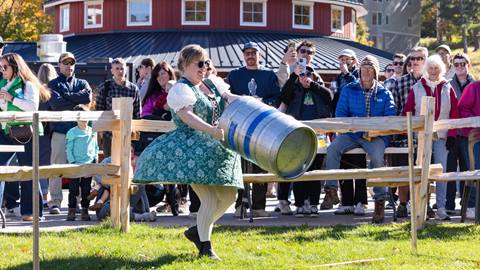 A woman throwing a keg at Oktoberfest