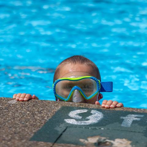 A little boy by the side of the pool
