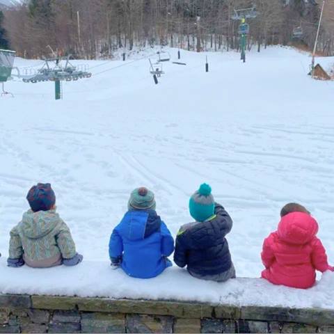 Kids sitting on a bench in the snow