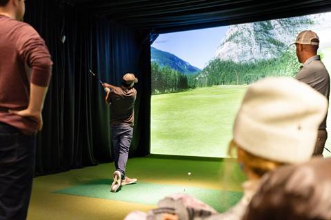 Golf with friends at an indoor golf simulator