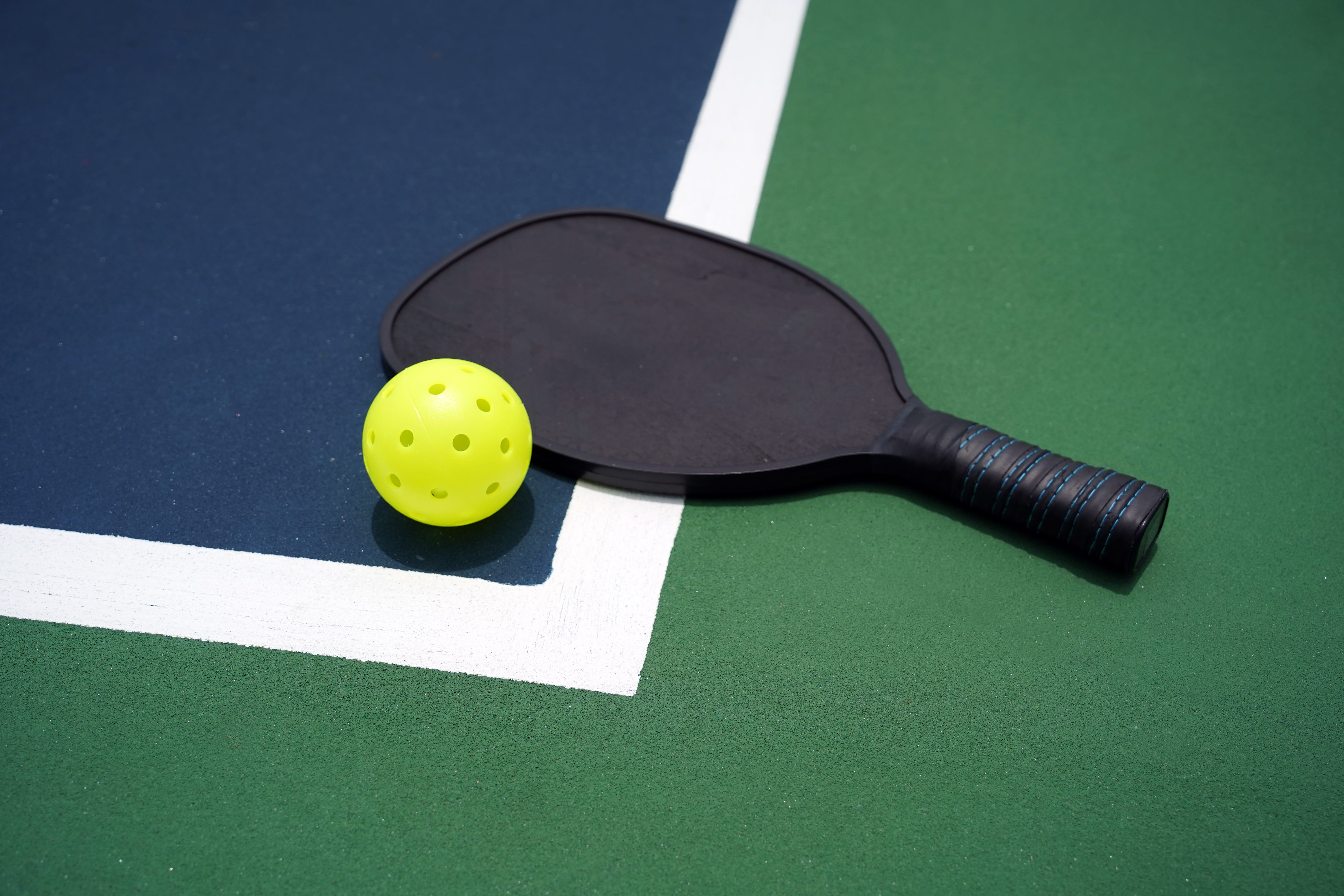 pickleball racket and ball on court