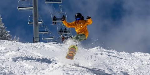Guy in a yellow jacket ripping down ripcord. 