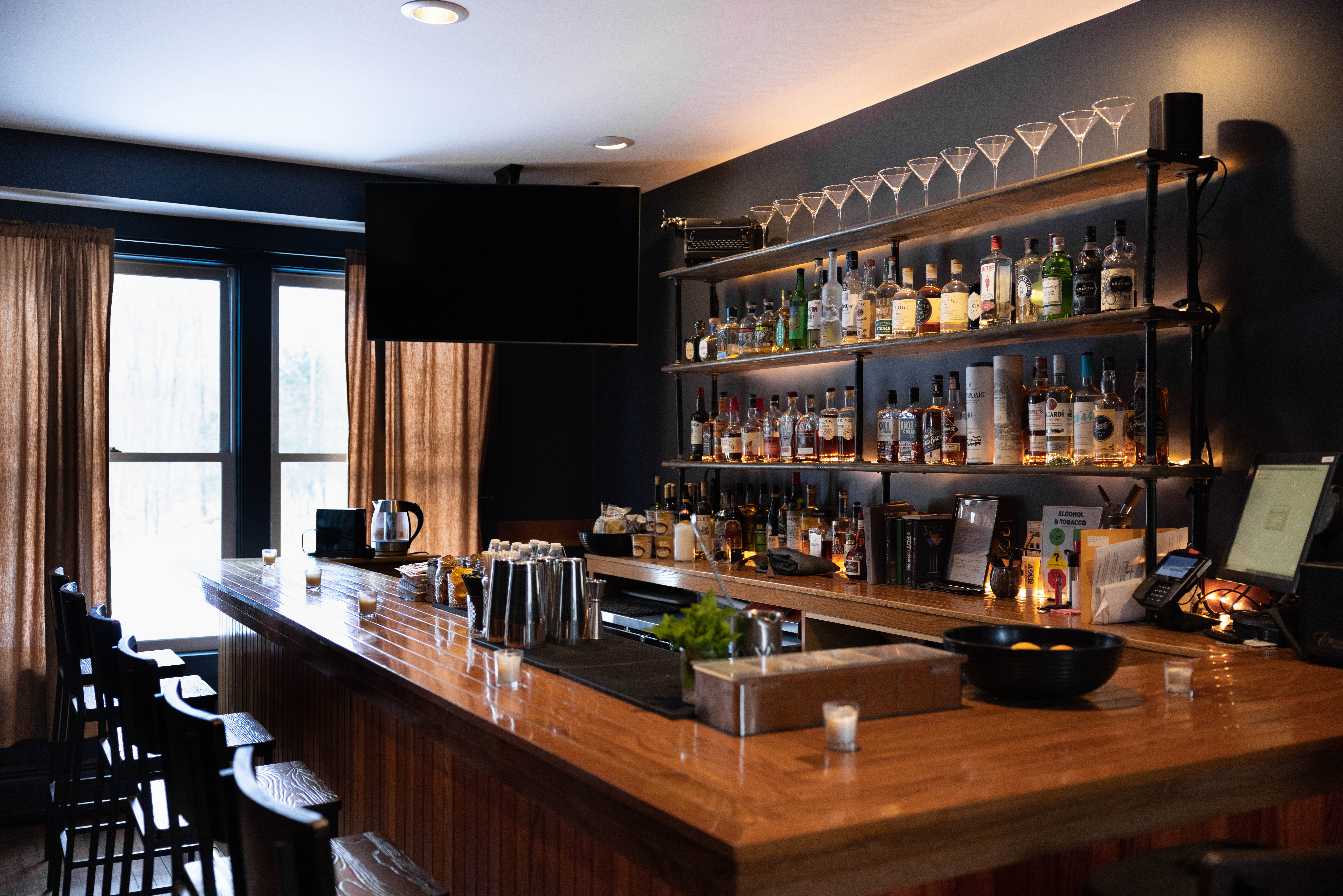 Wooden bar with liquor on shelving behind